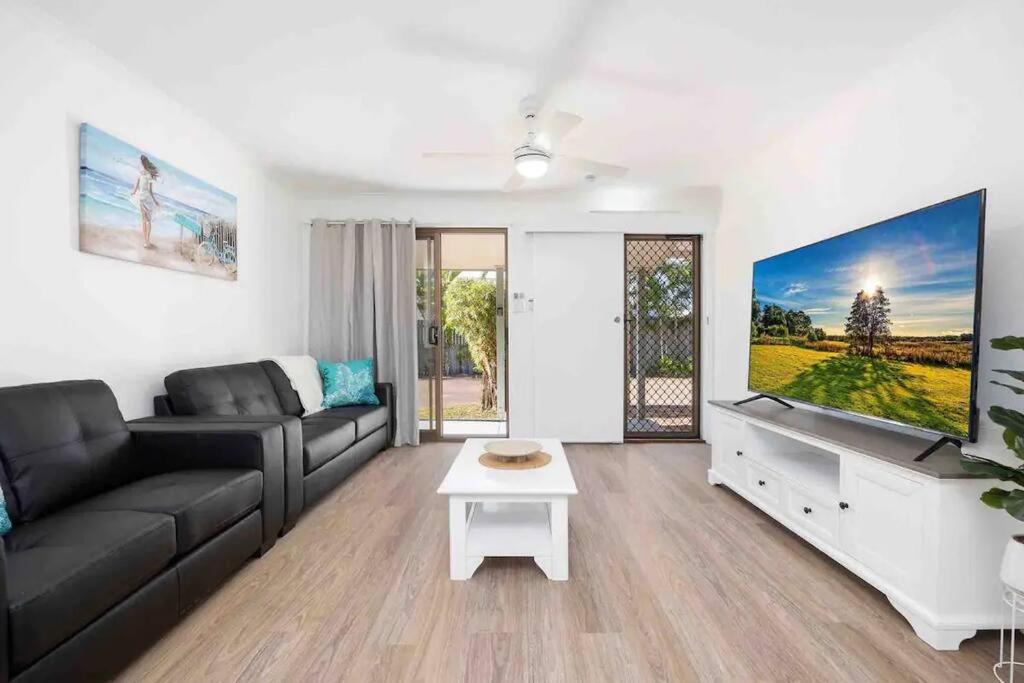 a living room with a couch and a flat screen tv at Hervey Bay Shelly Beach Stay ,Pet Friendly 300m to beach in Torquay