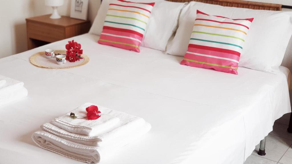 a bedroom with a white bed with towels and pillows at VILLA TO' in Àrbatax