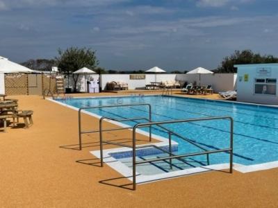a large swimming pool with stairs in a hotel at Selsey Country Club Valencia Chalet in Selsey