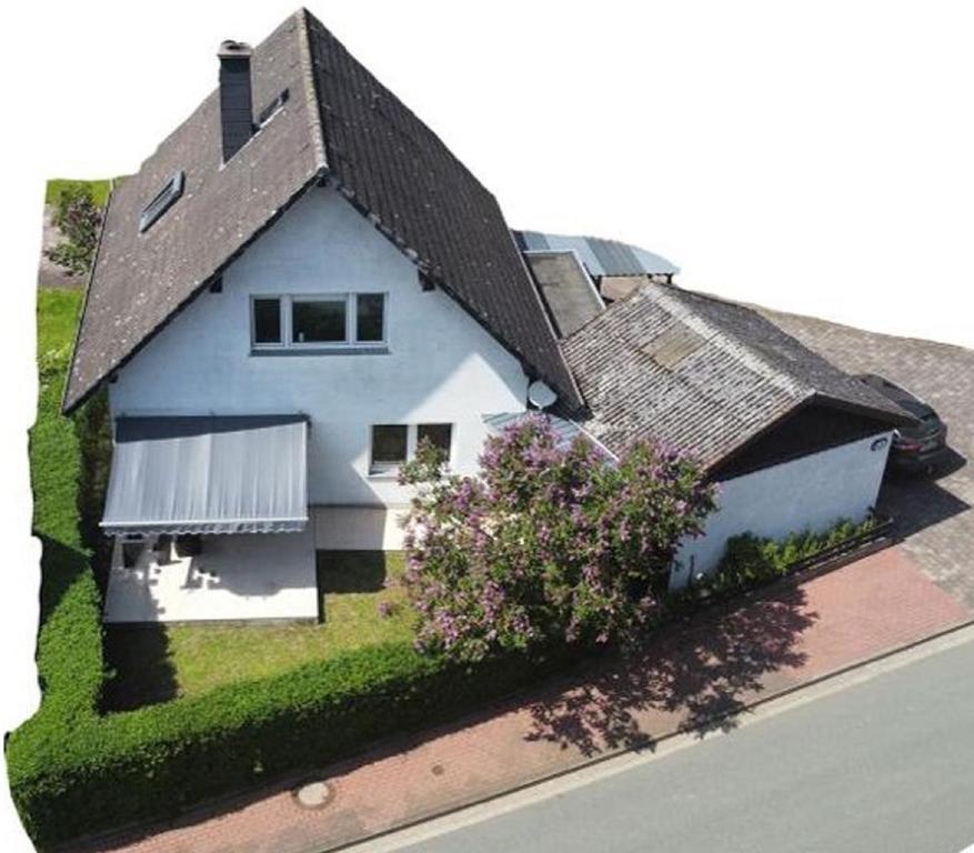 une maison blanche avec un toit noir dans une rue dans l'établissement Ferienhaus Baarsen 30, à Bad Pyrmont