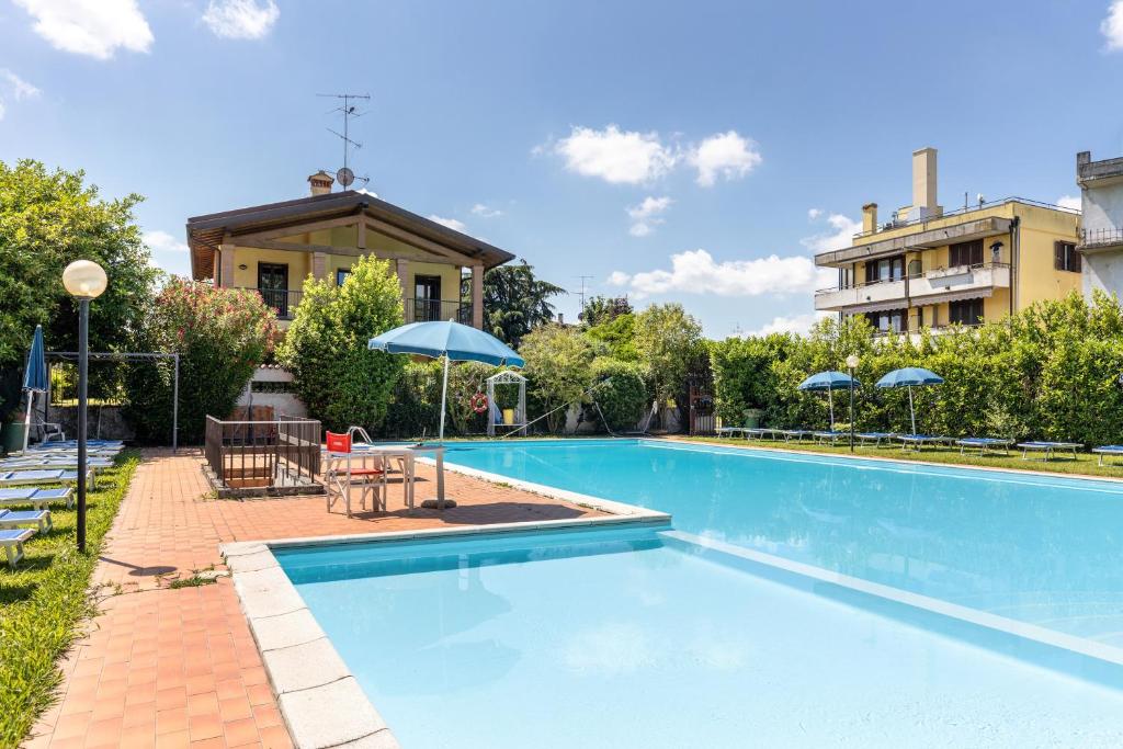 una piscina con sombrillas junto a un edificio en Casa Cattaleya, en Desenzano del Garda