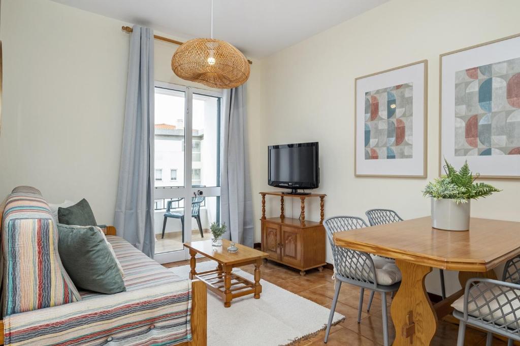 a living room with a couch and a table at Escapadinha do Sol by Homie in Pontinhas