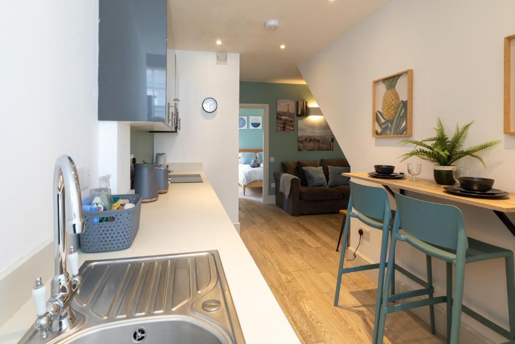 een keuken en een woonkamer met een wastafel en een aanrecht bij The Old Stables in Southampton
