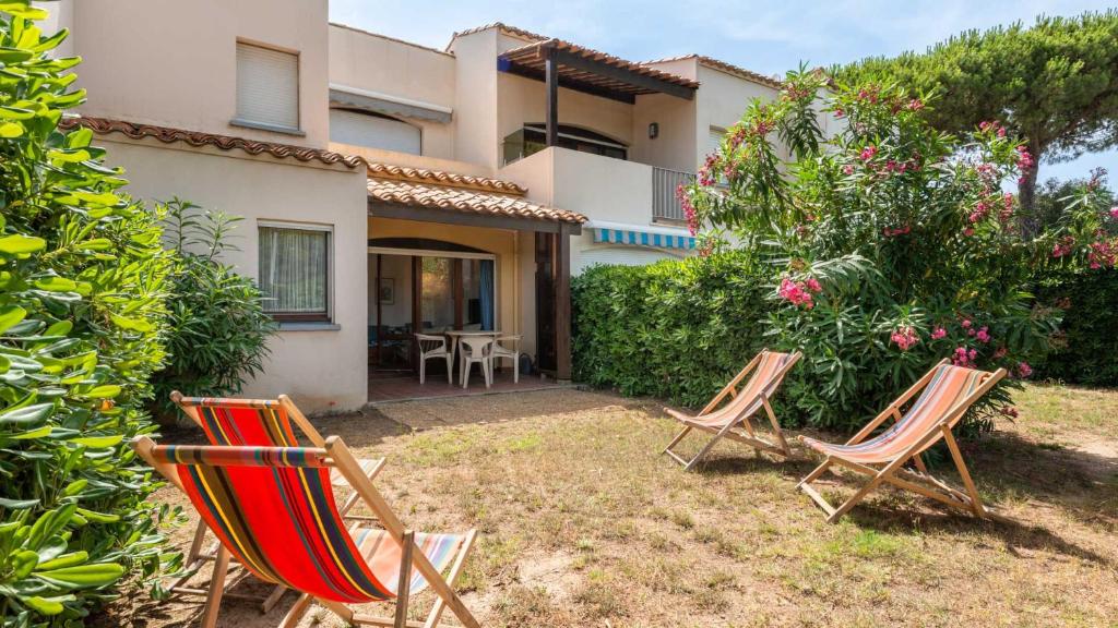 un groupe de chaises devant une maison dans l'établissement Port Lano - 3 - Appt lumineux 4-6 pers, au Cap d'Agde