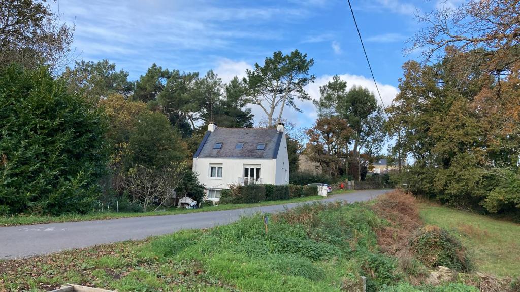 a white house on the side of a road at Appartement dans maison de campagne au calme in La Trinité-sur-Mer