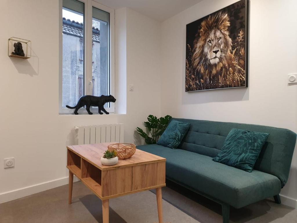 ein Wohnzimmer mit einer grünen Couch und einem Löwen an der Wand in der Unterkunft Le Jungle in Pamiers