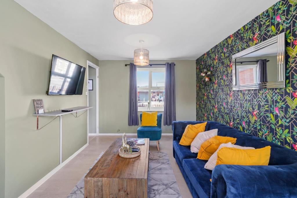 sala de estar con sofá azul y mesa en Stunning 3 bed Abode in Nuneaton- Sleeps 7 en Nuneaton