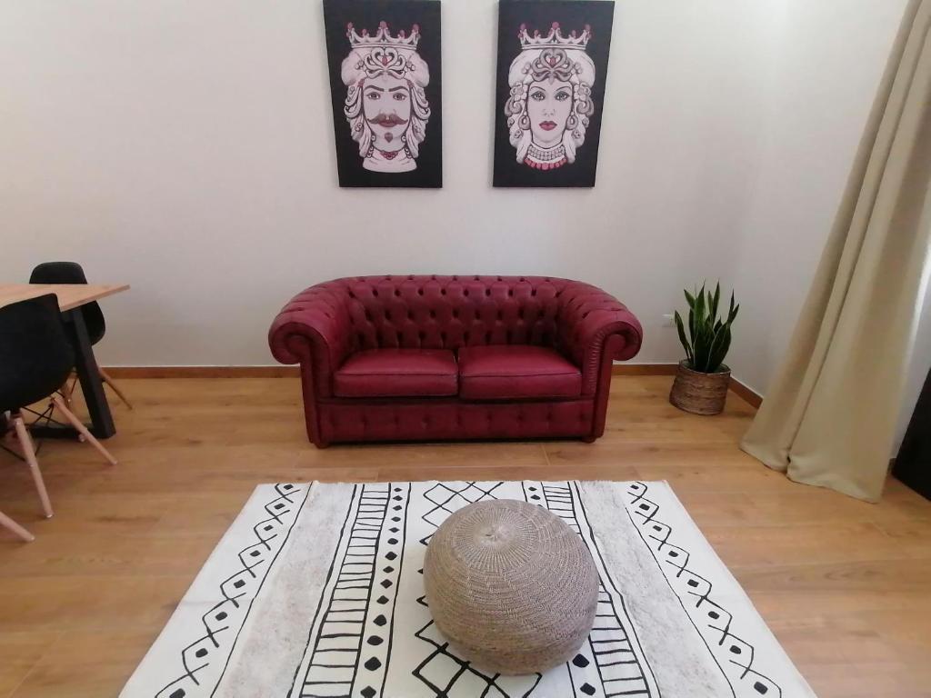 sala de estar con sofá rojo y alfombra en Appartamento I Mori, en Cassibile