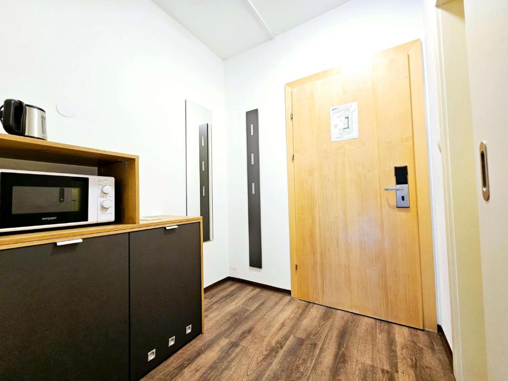a room with a microwave and a door at Familienhotel Trebesingerhof in Trebesing