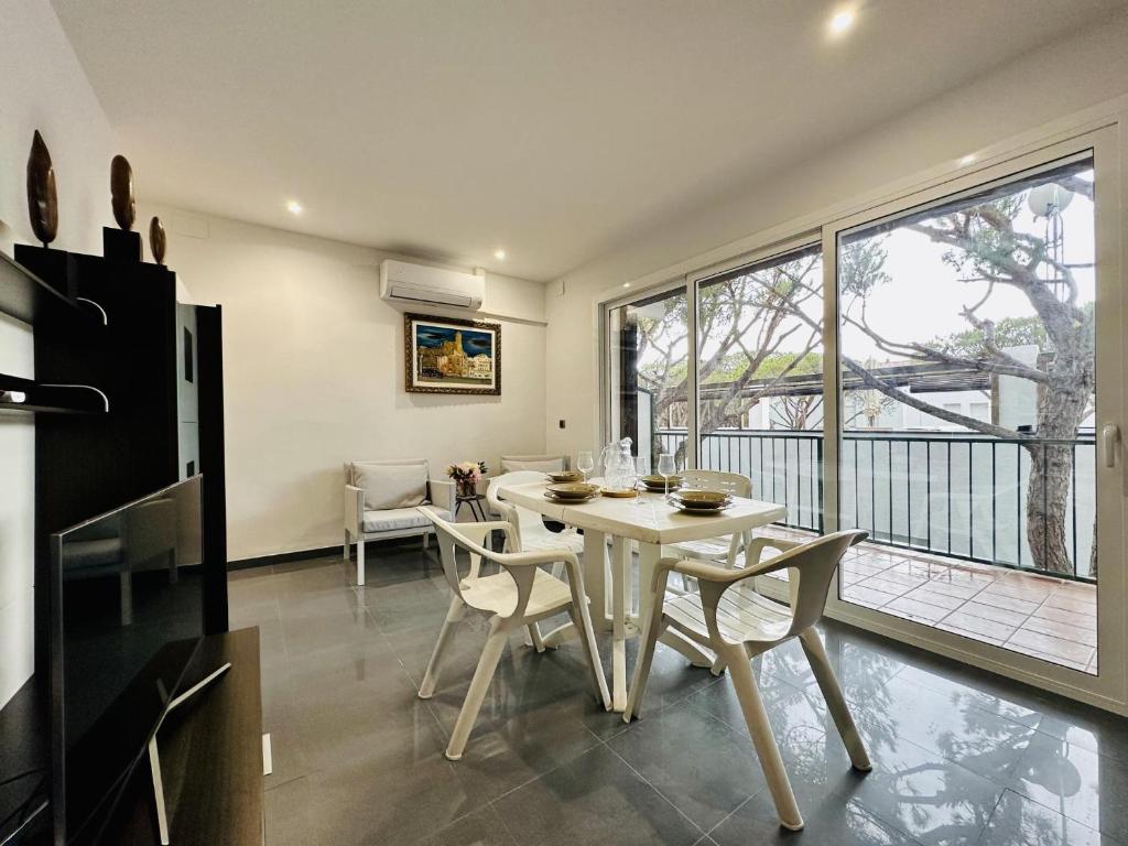 a dining room with a table and chairs and a balcony at Paradis CostaBravaSi in Platja d'Aro