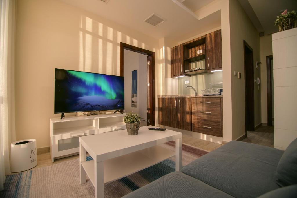 a living room with a tv and a white coffee table at 46 Serviced Apartments in Amman