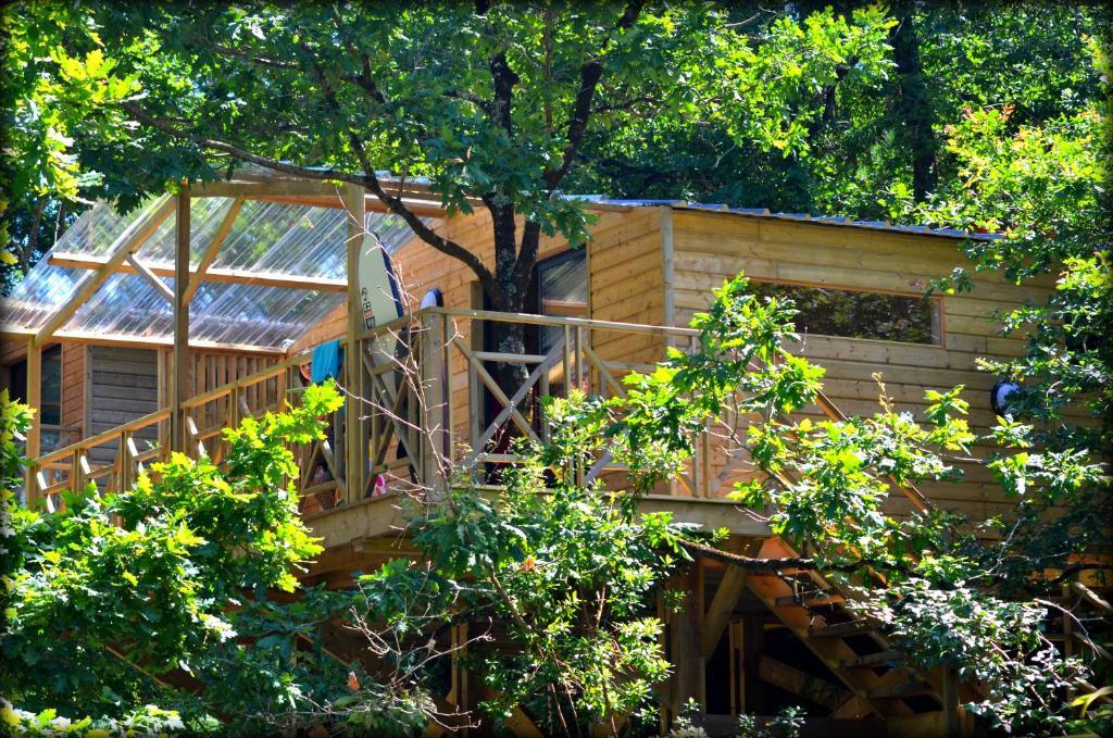 a tree house with a wooden staircase in the woods at Cabane ''Robinson'' dans les arbres de Nature et Océan à côté de la plage in Messanges