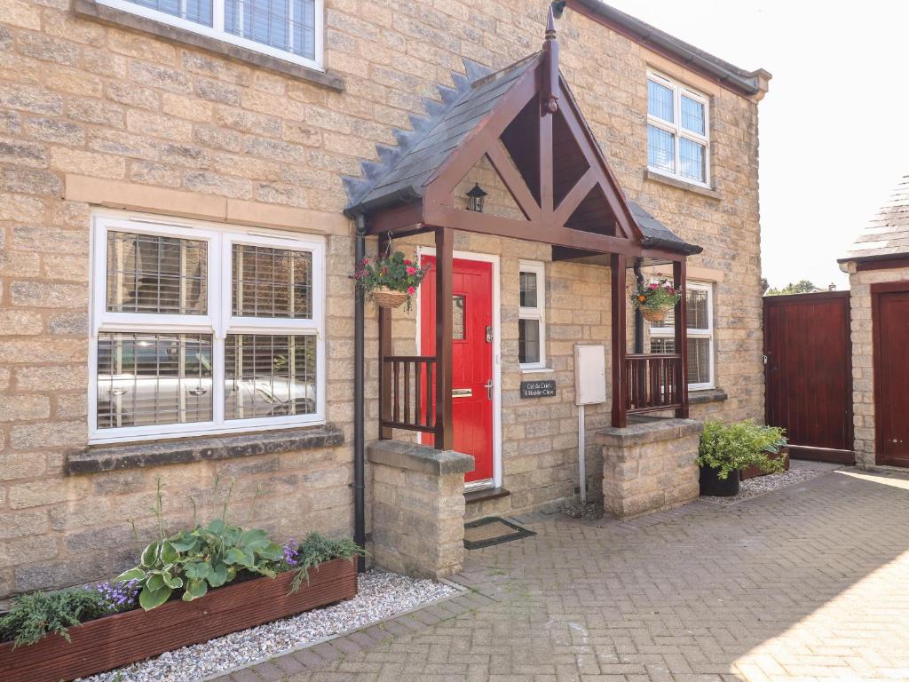 a brick house with a red door at Col du Crich in Matlock