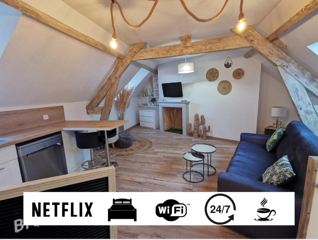 ブローニュ・シュル・メールにあるAcapulco, Superbe souplex proximité vieille villeの青いソファとキッチンのあるリビングルーム