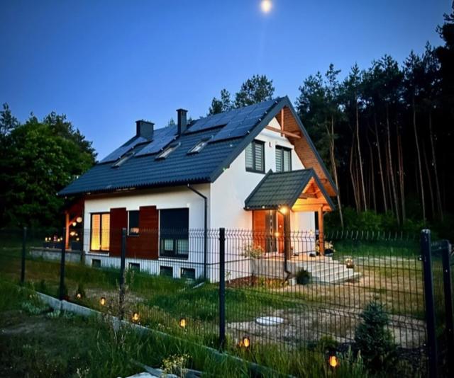 una piccola casa bianca con tetto nero di Blue Lake Villa a Gostycyn