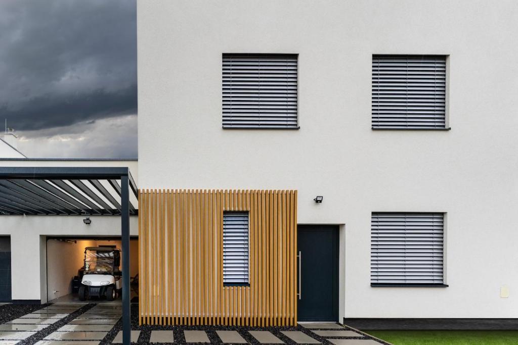 a white house with a yellow and white facade at Malina Penati golf in Šajdíkove Humence