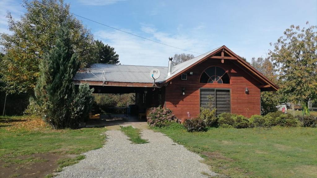une maison en briques rouges avec un toit en gambrel dans l'établissement Cabañas los Pinos, à Villarrica