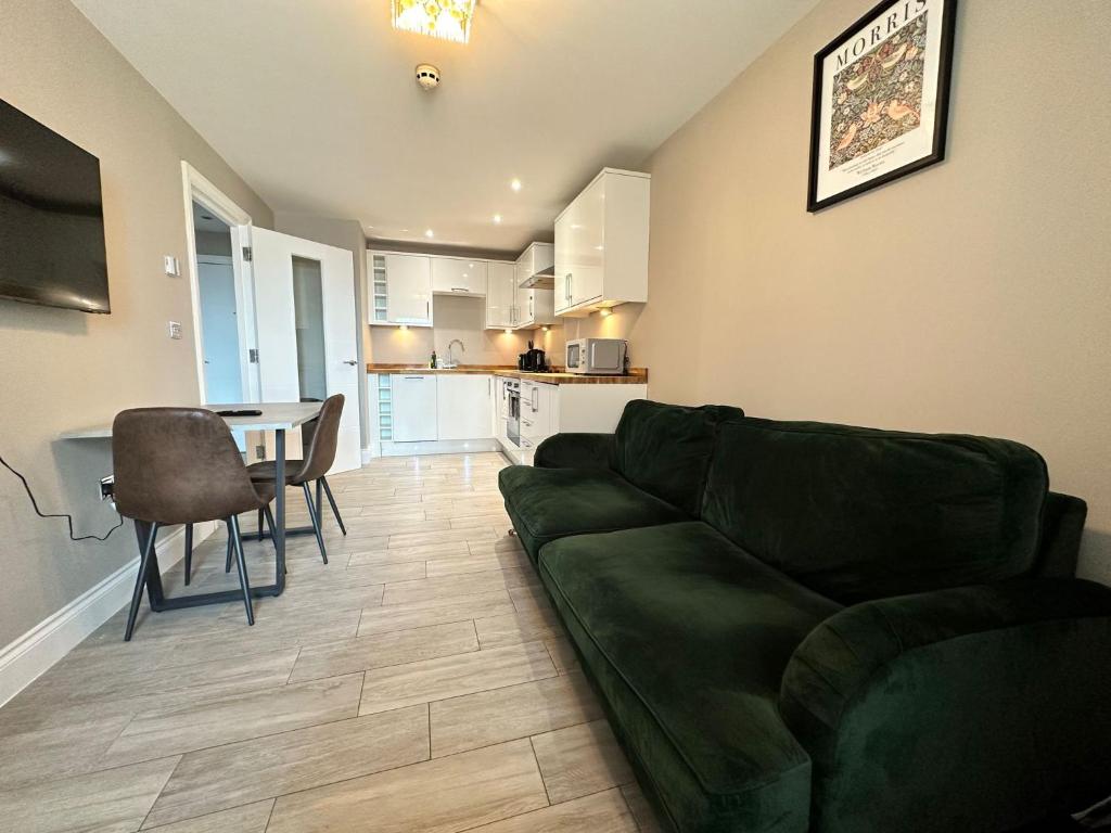 uma sala de estar com um sofá verde e uma mesa em Seaview Central Brighton One Bedroom Flat em Brighton & Hove
