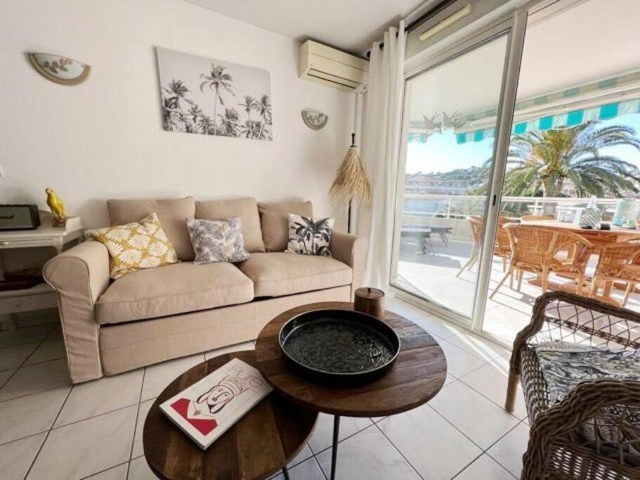 a living room with a couch and a table at Bel appartement 3 pièces climatisé 400m des plages in Cavalaire-sur-Mer
