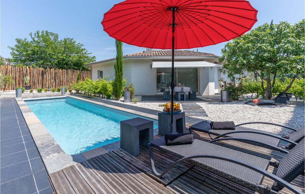 una sombrilla roja sentada junto a una piscina en Nice Home In Bordeaux With Outdoor Swimming Pool en Burdeos