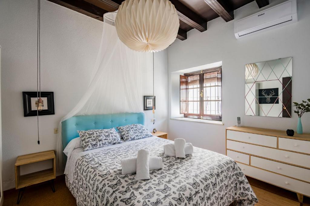 een slaapkamer met een groot bed met een blauw hoofdeinde bij Apartamento Historico Garaje y WIFI in Sanlúcar de Barrameda