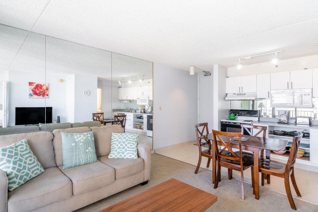 a living room and kitchen with a couch and a table at Light & Airy Waikiki Condo with Private Lanai condo in Honolulu