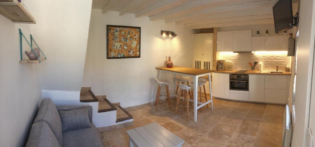 a kitchen with a couch and a table in a room at Au calme dans le centre avec terrasse et clim in Saint-Rémy-de-Provence