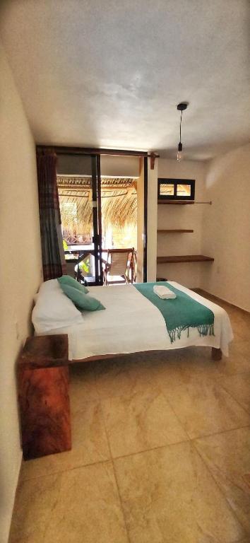a bedroom with a large bed and a window at Casa Yoo Bigu Mazunte in Mazunte