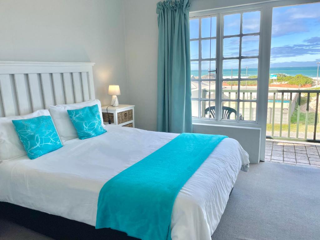 a bedroom with a bed with a view of the ocean at 26 Settler Sands Beachfront Accommodation Sea View in Port Alfred