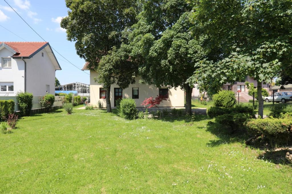 un patio con una casa y un árbol en Maple place en Velika Gorica