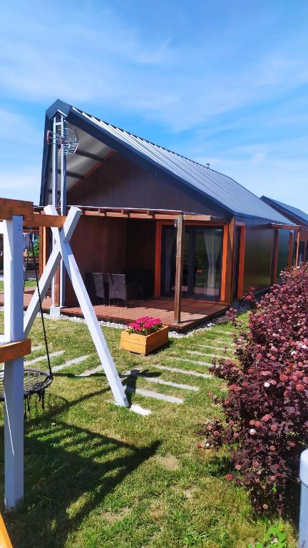 ein Haus mit blauem Dach und ein paar Blumen in der Unterkunft Koniczynka Jarosławiec in Jezierzany