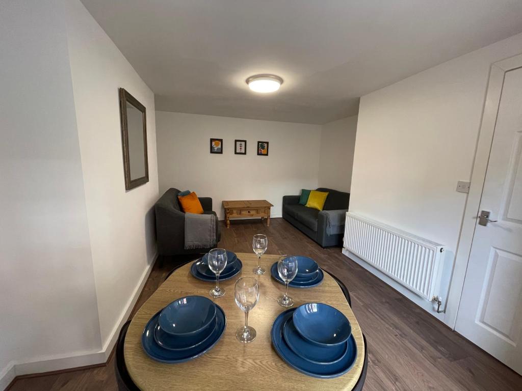 a dining room with a table with plates and wine glasses at The Crescent, Flat 1 - Stockport, Manchester in Manchester