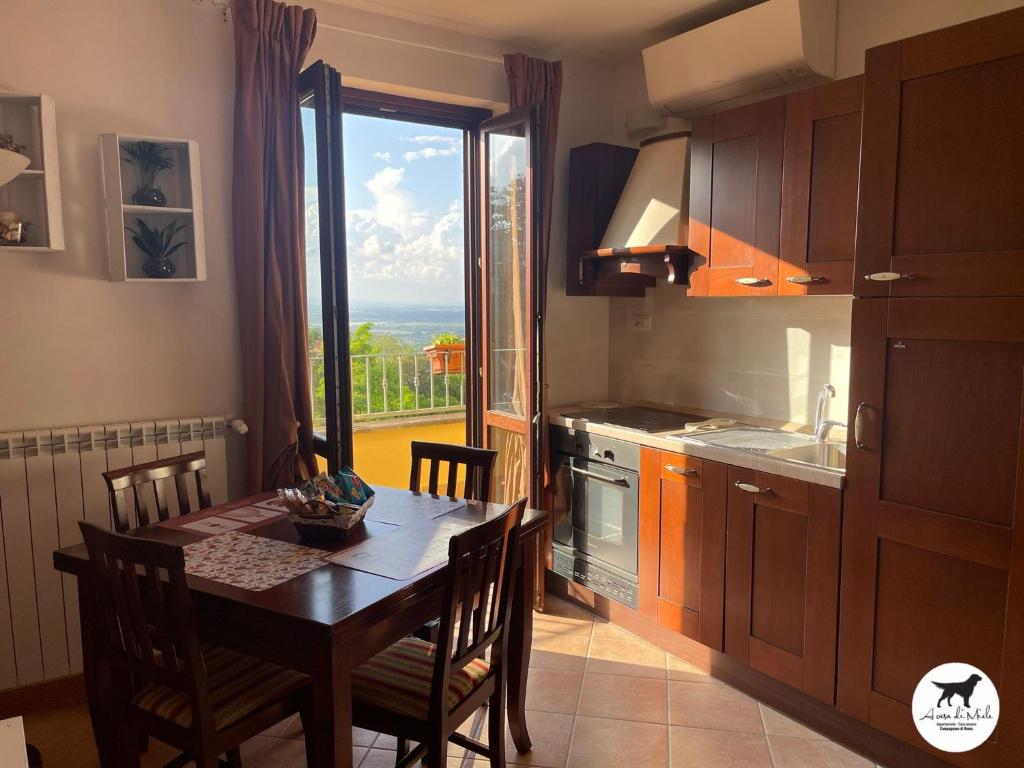 uma cozinha com uma mesa e uma grande janela em A casa di Miele em Campagnano di Roma
