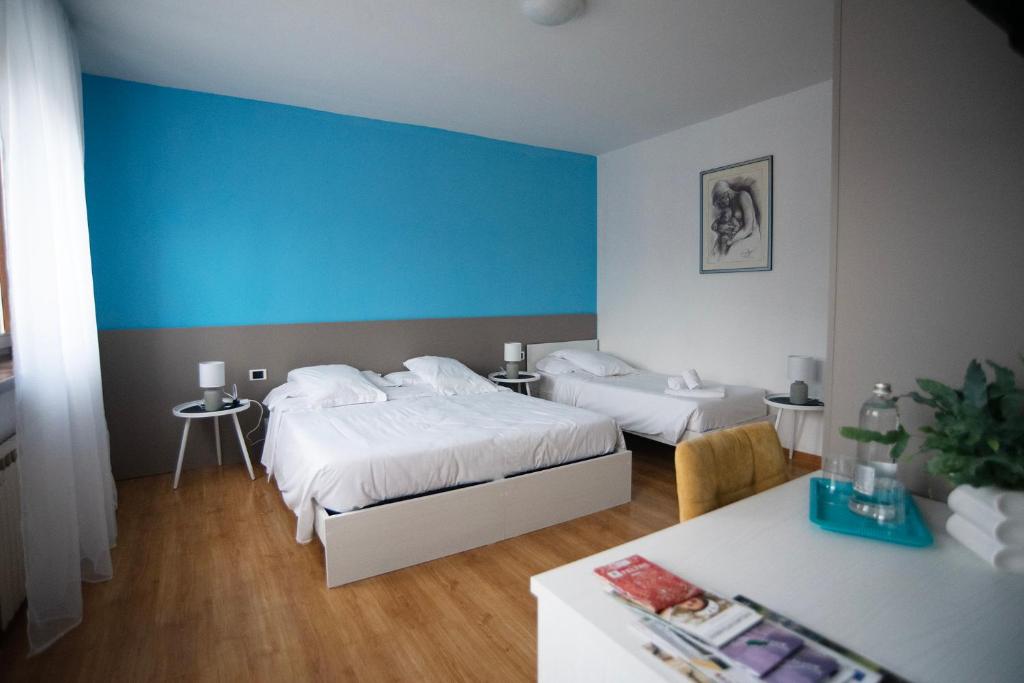 1 dormitorio con 2 camas y pared azul en Albergo Alla Cesa, en Feltre