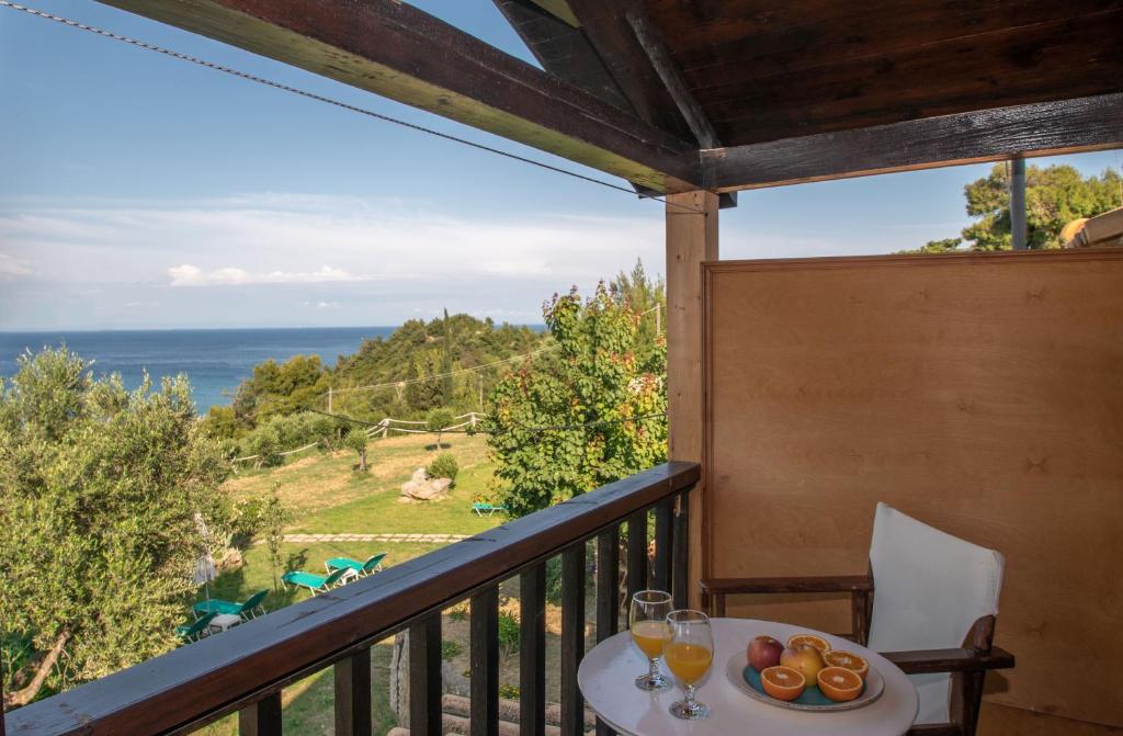 balcone con tavolo, bicchieri da vino e vista sull'oceano di Arpyia a Vasilikós