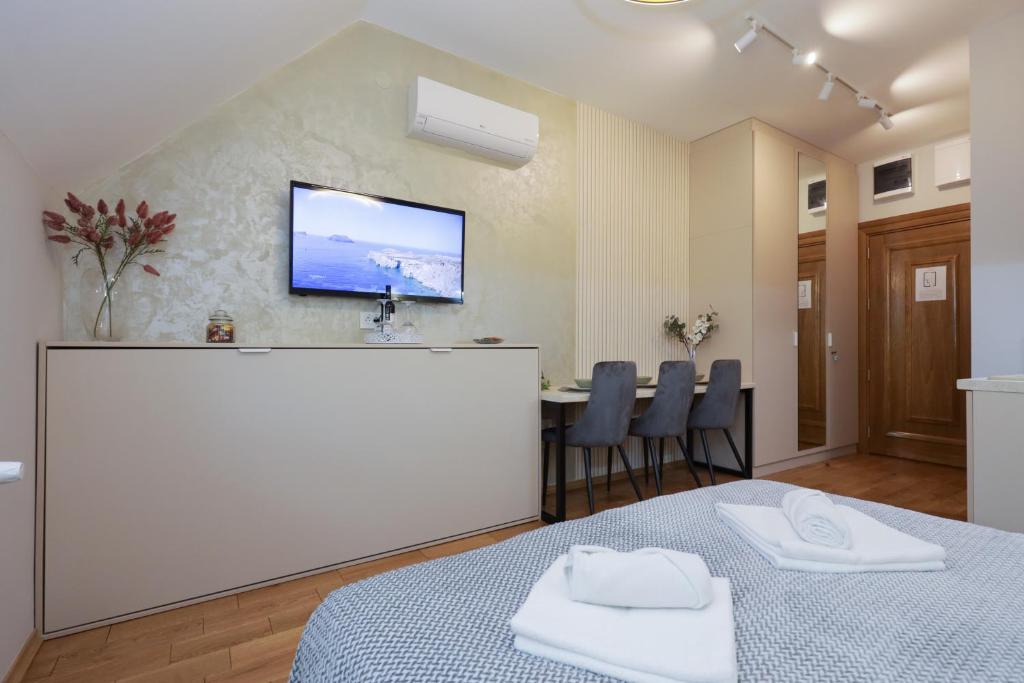 パリチにあるETA 2 APARTMENTのベッド1台と壁掛けテレビが備わる客室です。