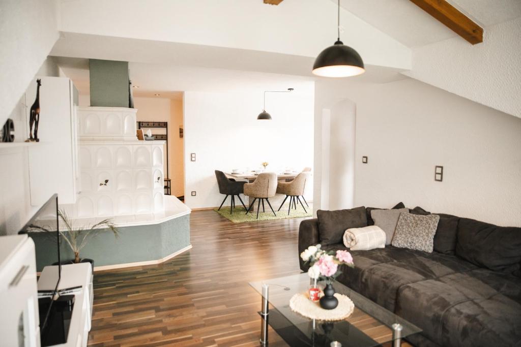 een woonkamer met een bank en een tafel bij Modernes Apartment mit Top Ausstattung und Kamin im Oberpfälzer Seenland in Nittenau