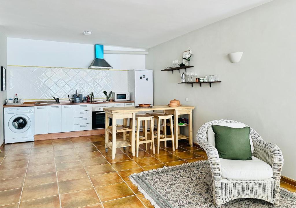 uma cozinha com uma mesa e uma cadeira em La Perla de Frigiliana Suites & Villa em Frigiliana