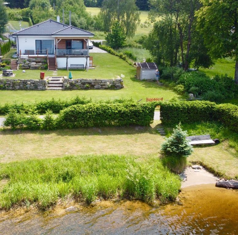 - une vue aérienne sur une maison à côté d'une rivière dans l'établissement Lipno Villa Beach - Lipno Stausee - Lakeside, à Loučovice