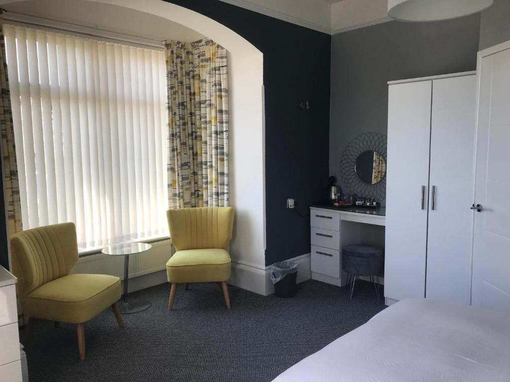 尚克林的住宿－聖萊昂納茨旅館，一间卧室配有一张床、两把椅子和一张书桌