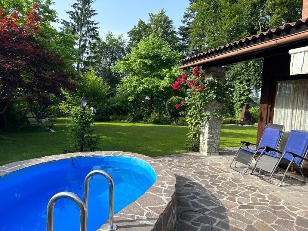 a swimming pool in a yard with two chairs at Family lake house Zbilje in Ljubljana
