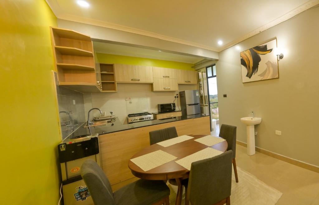 a kitchen and dining room with a table and chairs at Executive apartments at kileleshwa estate in wote town in Wote