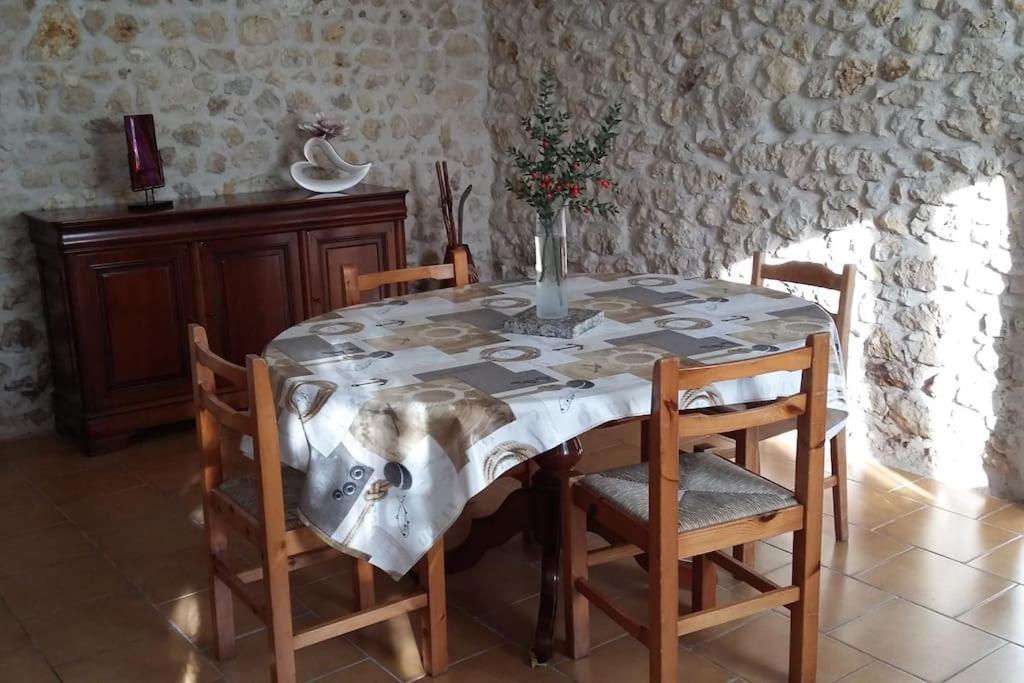 un tavolo da pranzo con sedie e un vaso sopra di CHARMANTE MAISON PAISIBLE 6 PERSONNES a Vendays-Montalivet