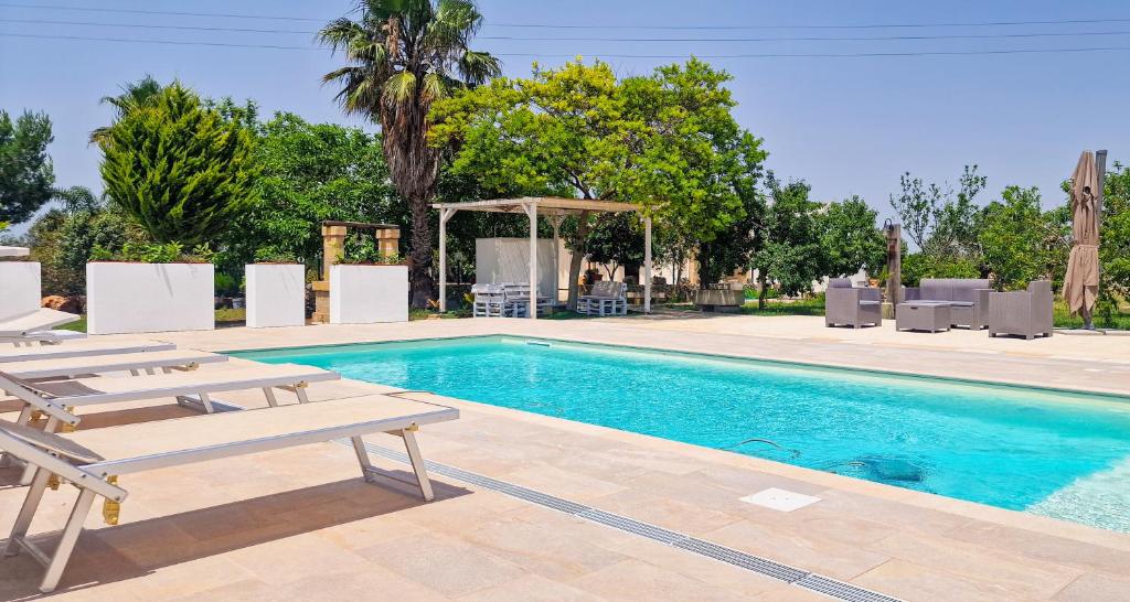 basen z 2 leżakami i stołem w obiekcie Villa Marzoni con Piscina Privata by HDSalento w mieście Tiggiano