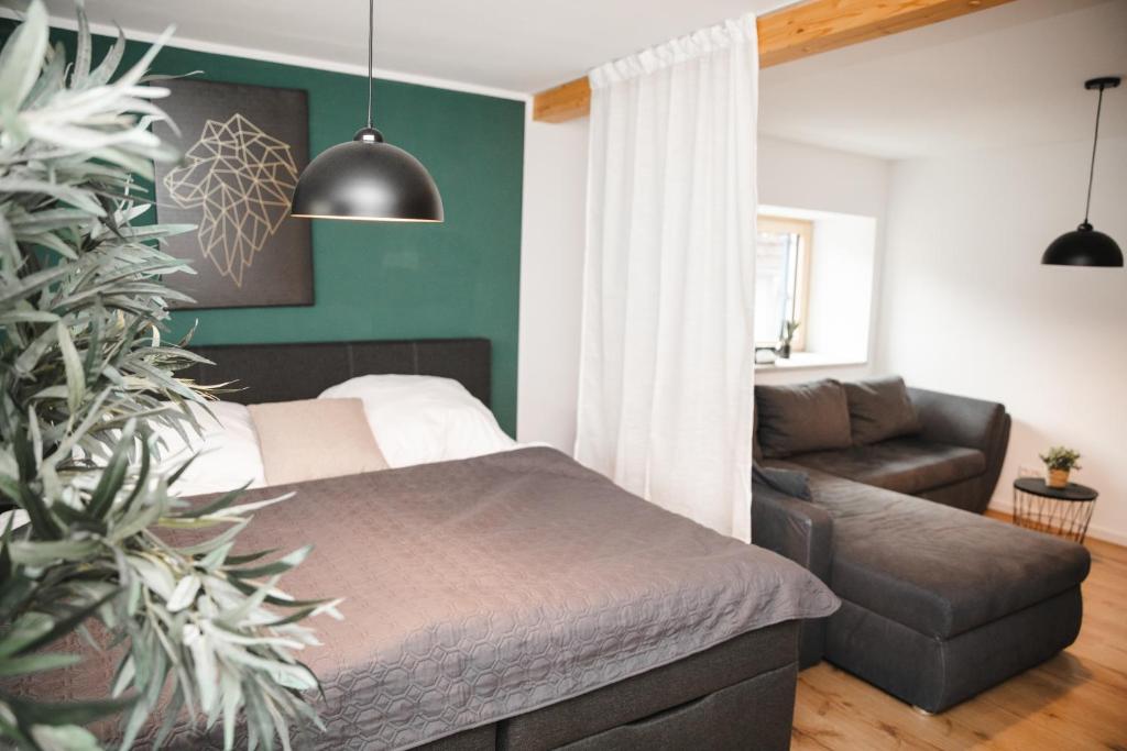 een slaapkamer met een bed en een bank bij Apartment mit Burgblick in Burglengenfeld