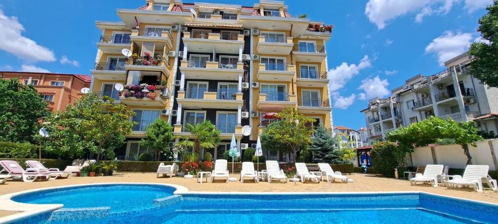 a hotel with a swimming pool in front of a building at Апартамент за гости Магнолия Резиденс in Sunny Beach