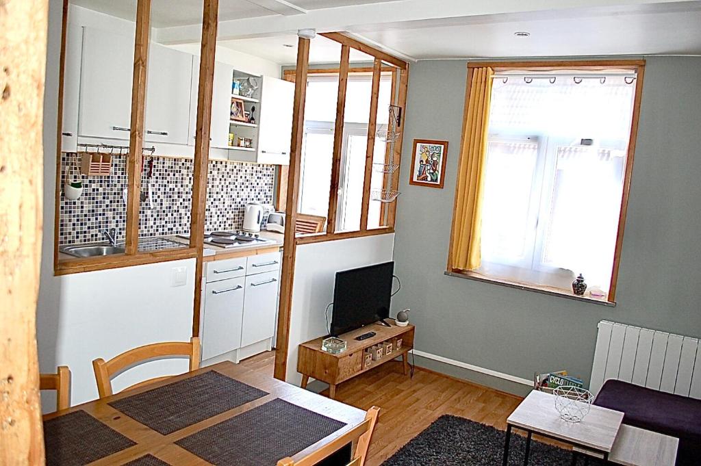 ein Wohnzimmer mit einem Tisch und einer Küche in der Unterkunft Citadelle Vauban, T2 l'encyclopédie in Lille
