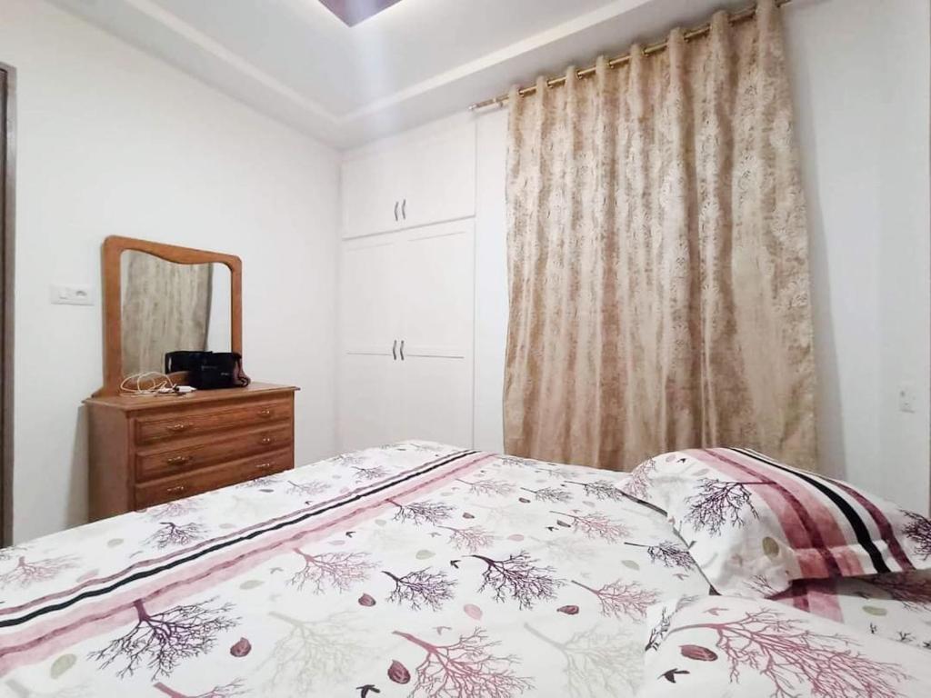 - une chambre avec un lit, une commode et un miroir dans l'établissement Villa s+3 500 métre du plage dar allouche anwer ferjeni, à Hennchir Ksar Rhaleb