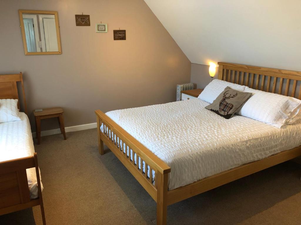 a bedroom with two beds in a room at The Old Post Office House BnB in Balmacara