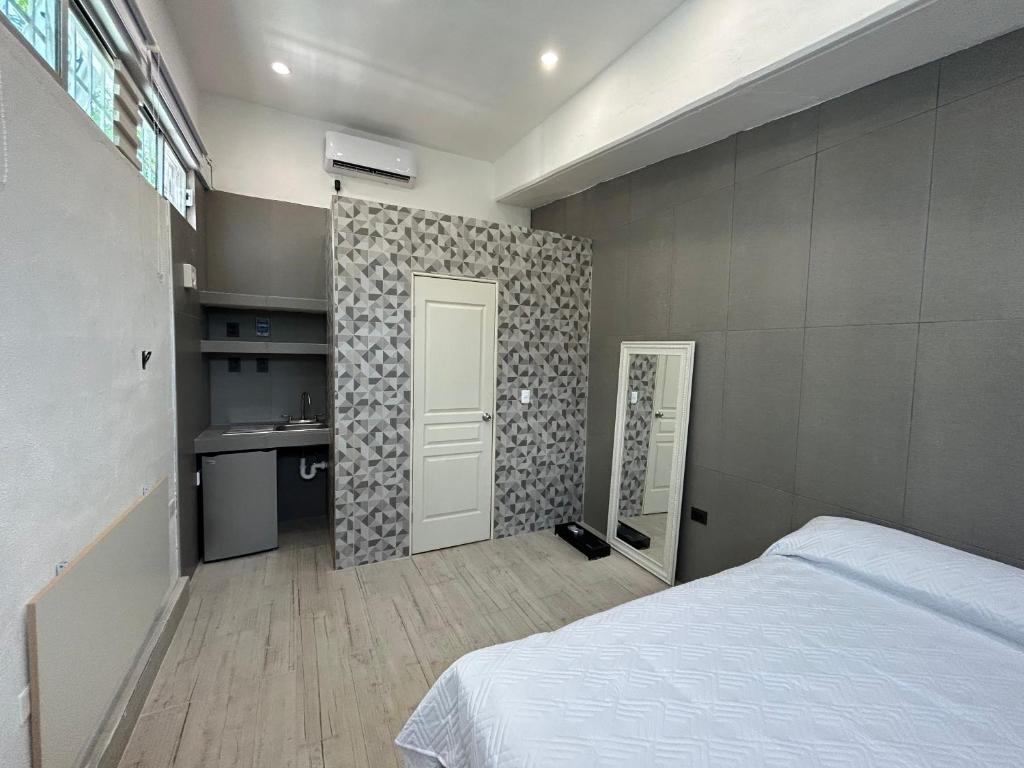 sypialnia z łóżkiem, biurkiem i drzwiami w obiekcie Rose 5 w mieście Cancún